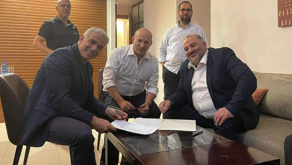 L-R: Yair Lapid, Naftali Bennett and Mansour Abbas signing the outline of their coalition agreement earlier this month in Ramat Gan (Photo: Nawaf al-Nabari) עבאס, בנט ולפיד לאחר החתימה בפגישה בכפר המכבייה