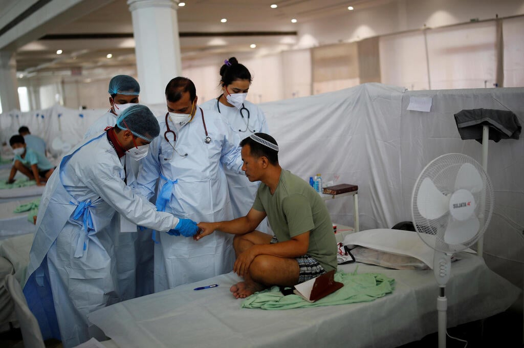 Health workers tend to an Indian Jew, member of the Bnei Menashe, suffering from coronavirus, at a COVID-19 care facility in New Delhi, India (Photo: Reuters) Health workers tend to an Indian Jew, member of the Bnei Menashe, or the Children of Menashe, one of the "lost tribes of Israel" from the India's northeastern state of Manipur, suffering from the coronavirus disease (COVID-19), at a COVID-19 care facility, inside a Gurudwara or a Sikh Temple, in New Delhi, India