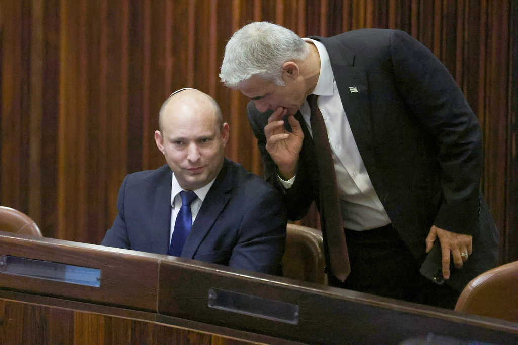 Naftali Bennett and Yair Lapid talking in the Knesset as MKs voted for a new president, June 2, 2021 (Photo: Reuters) נפתלי בנט ויאיר לפיד מדברים במליאת הכנסת