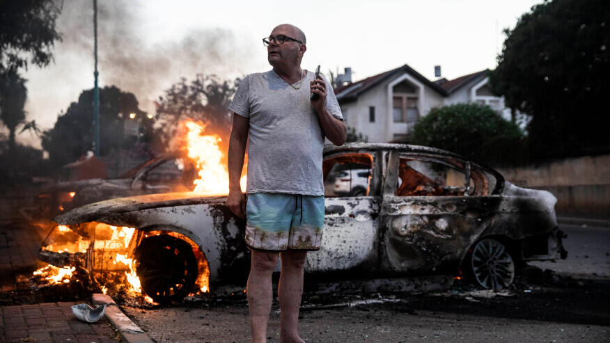 A local resident stands by his burning car during clashes between Israeli Arabs and police in Lod, May 11,2021 
