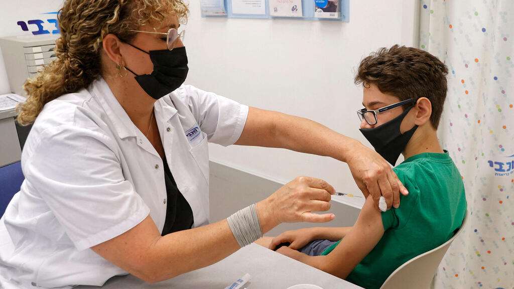 A 12-year old boy receives his coronavirus vaccine in Tel Aviv earlier this month (Photo: AFP) מיכאל, בן 12 מתל אביב, מתחסן