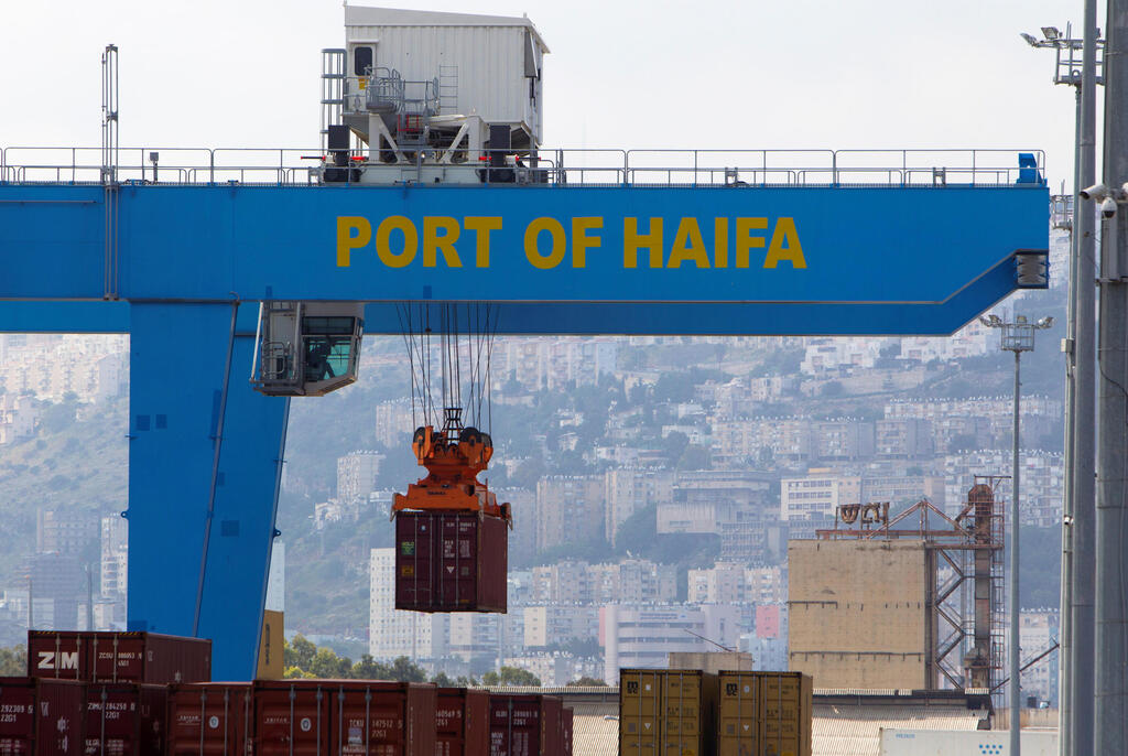 A crane unloads a container at the port of the northern city of Haifa