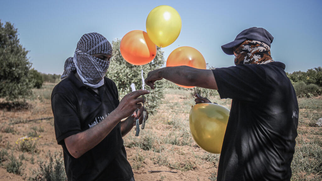 Palestinian militants in the Gaza Strip preparing to launch explosive-laden balloons into Israel (Photo: Getty Images) פלסטינים בעזה מכינים בלוני נפץ