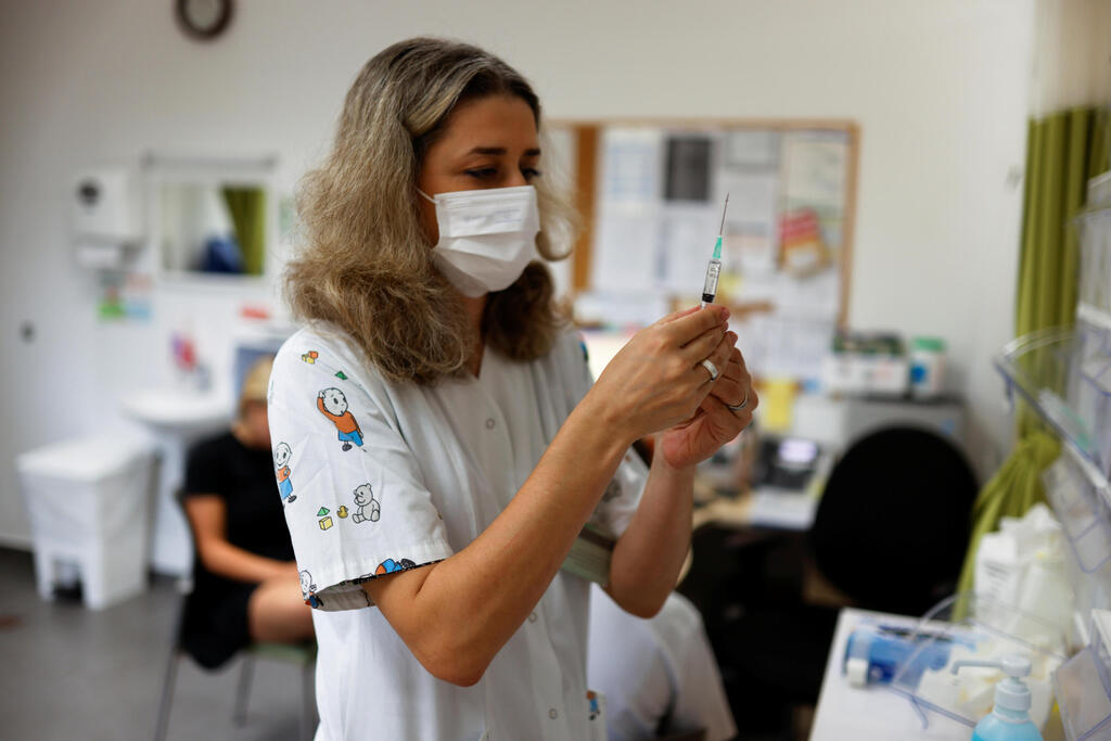 A teenager receives a dose of a vaccine against the coronavirus disease at Clalit HMO in Tel Aviv  