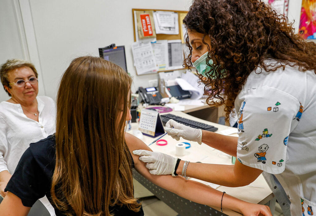 A teenager receives the COVID vaccine in the central city of Holon (Photo: AFP) מחסנים בני נוער בחולון
