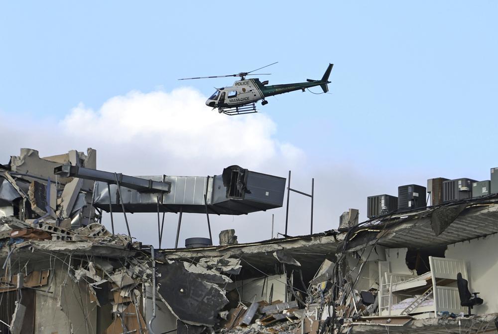 A Miami-Dade Police helicopter flies over the Champlain Towers South Condo (Photo: AP) A Miami-Dade Police helicopter flies over the Champlain Towers South Condo