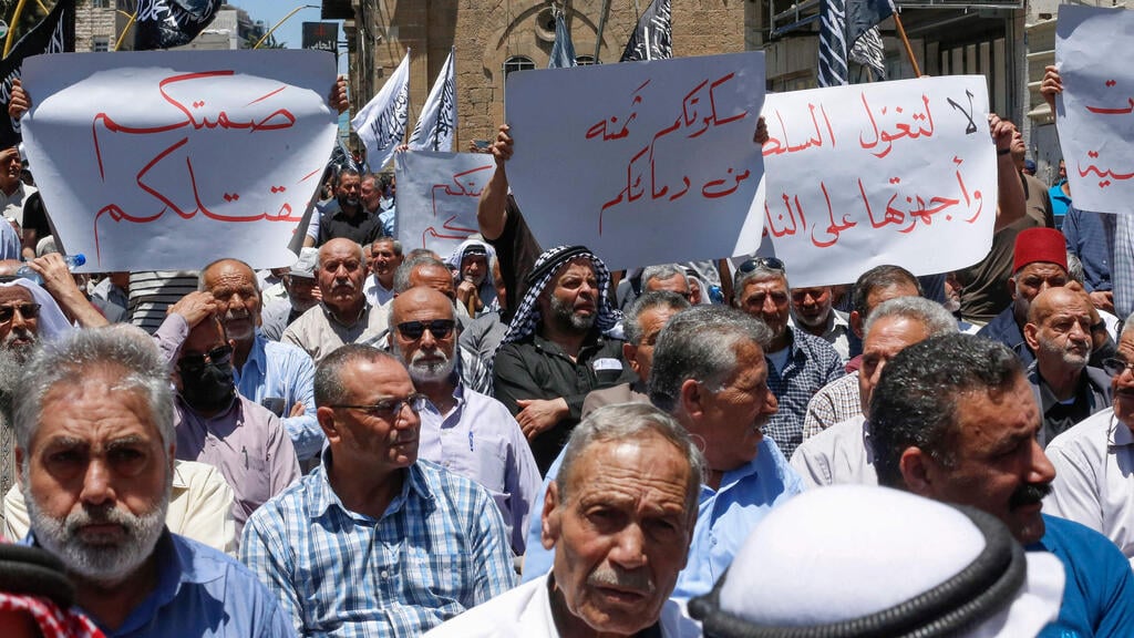 Palestinians protest death of detainee in PA jail last year (Photo: AFP) הפגנות בחברון כמחאה על מותו של הפעיל הפלסטיני ניזאר בנאת