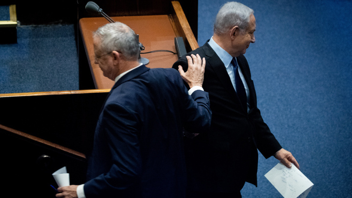 Benny Gantz pats then-Prime minister Benjamin Netanyahu on the shoulder