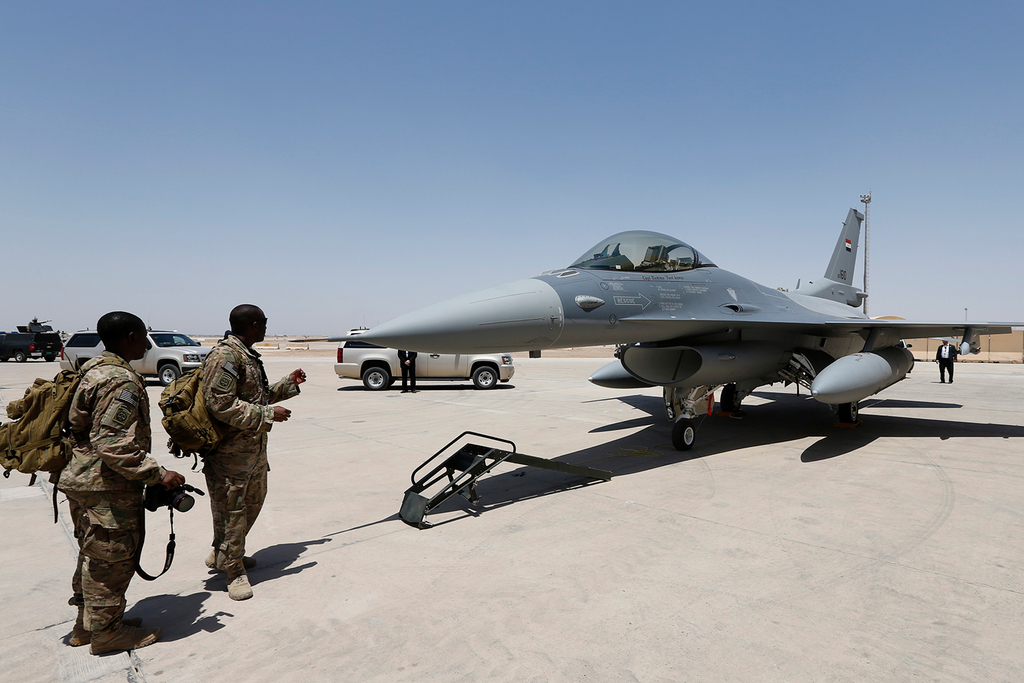  U.S. Army soldiers look at an F-16 fighter jet during an official ceremony to receive four such aircraft from the United States, at a military base in Balad, Iraq 