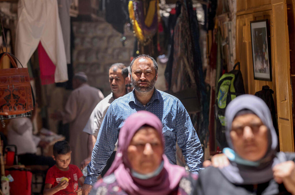 Human rights activist Issa Amro walks through the market in Hebron