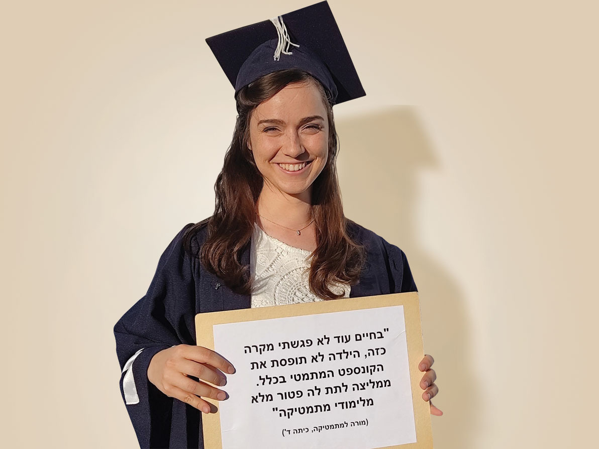 נעמי-טל צברי טקס סיום התואר, עם השלט שהכינה לה אמה, ובו ציטוט של מה שאמרה עליה מורה בכיתה ד' (צילום: יהודית קגן) נעמי טל צברי