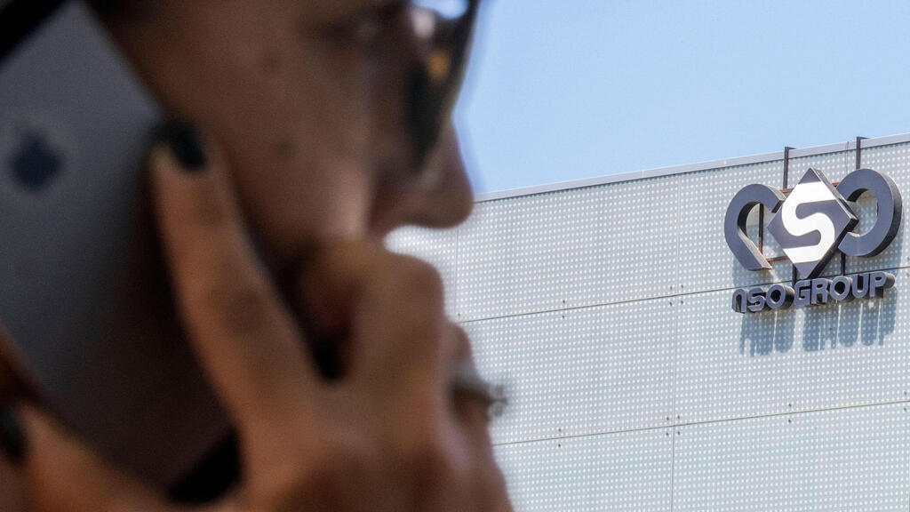 Israeli woman uses her iPhone in front of the building housing the Israeli NSO group, in Herzliya, near Tel Aviv 