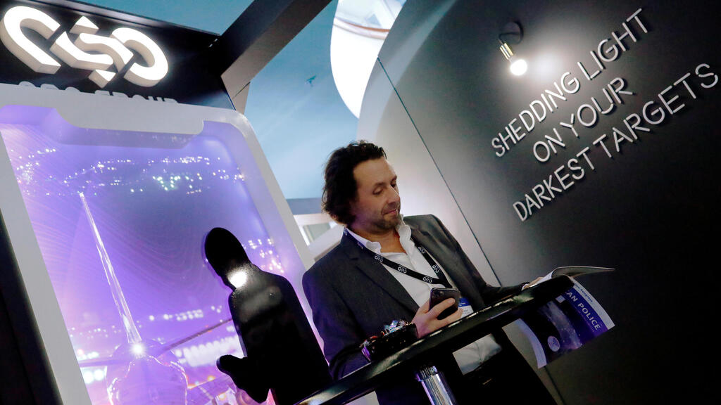 A man reads at a stand of the NSO Group Technologies, an Israeli technology firm known for its Pegasus spyware enabling the remote surveillance of smartphones, at the annual European Police Congress in Berlin 