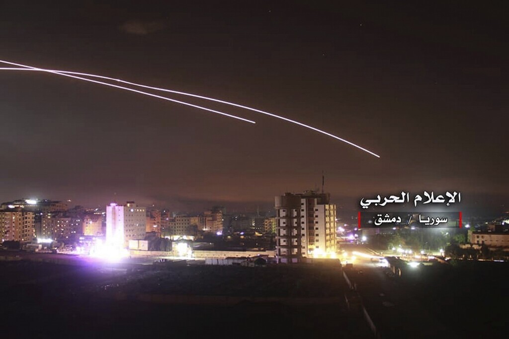 A photo provided by the pro-regime Syrian Central Military Media, shows anti-aircraft fire rise into the sky as Israeli missiles hit air defense positions and other military bases around Damascus, Syria, 
