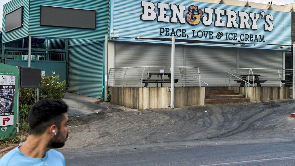 motorist drives past a closed "Ben & Jerry's" ice-cream shop in the Israeli city of Yavne, about 30 kilometres south of Tel Aviv, on July 23, 2021