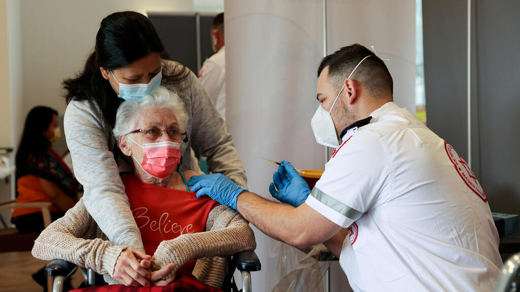 An elderly woman receives a booster shot of her vaccination against the coronavirus disease (COVID-19) at an assisted living facility, in Netanya, Israel January 19, 2021 