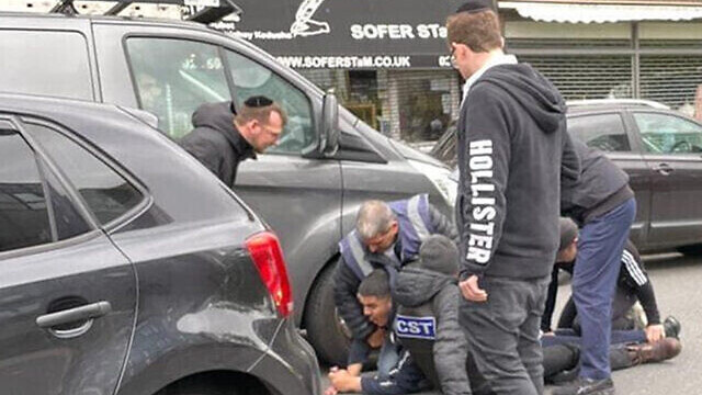 Men from the CST and Shomrim security units detain the alleged attacker of a Jewish man in his car in London, May 21, 2021 (Photo: JTA) Men from the CST and Shomrim security units detain the alleged attacker of a Jewish man in his car in London, May 21, 2021