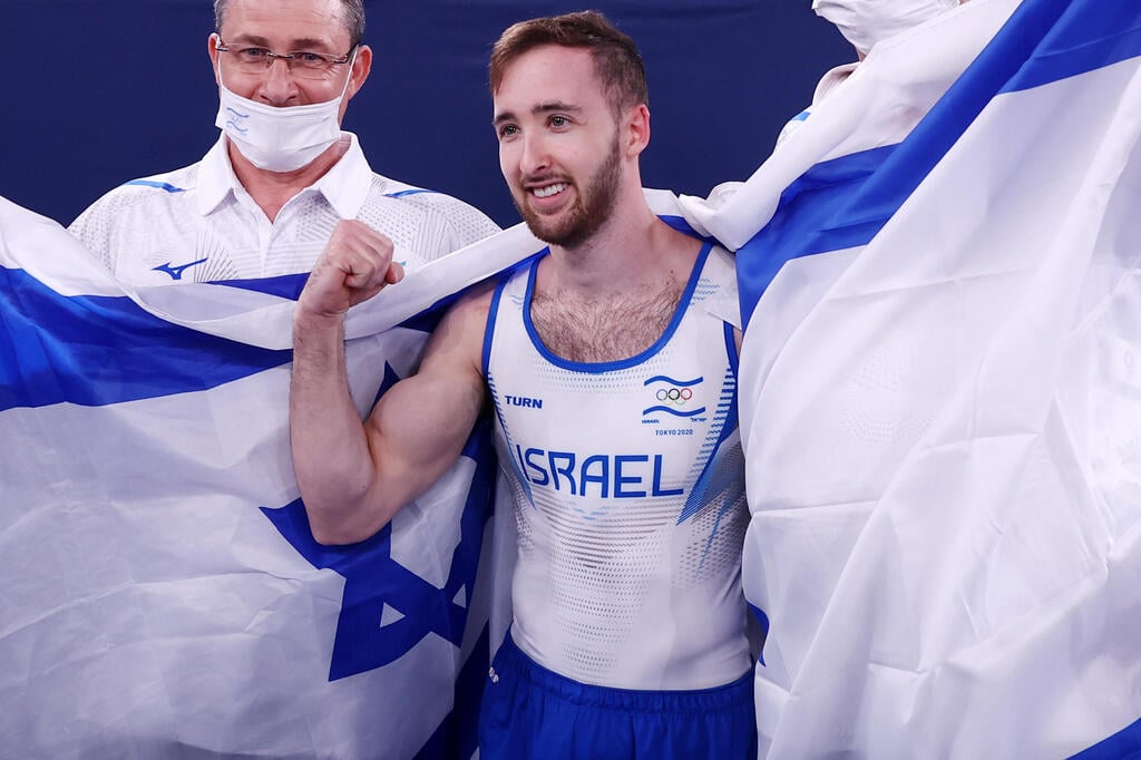 Artem Dolgopyat draped in the Israeli flag after winning the gold medal for Men's Floor gymnastics at the Tokyo Olympics (Photo: Reuters) דולגופיאט חוגג