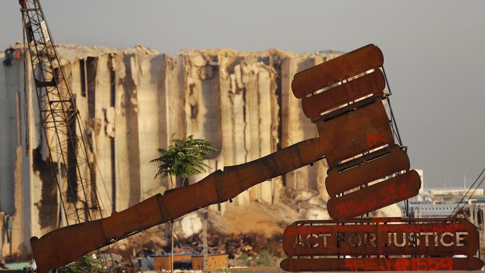 A justice symbol monument is seen in front of towering grain silos that were gutted in the massive August 2020 explosion at the port that claimed the lives of more than 200 people, in Beirut, Lebanon (Photo: AP) A justice symbol monument is seen in front of towering grain silos that were gutted in the massive August 2020 explosion at the port that claimed the lives of more than 200 people, in Beirut, Lebanon