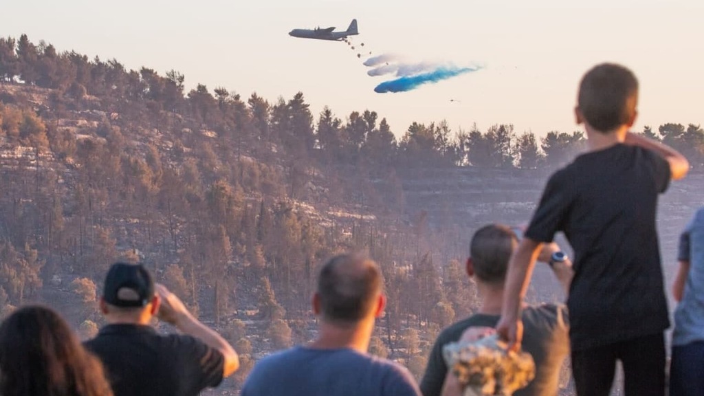Crowd looks as water bomber discharges fire extinguishing agent on wildfire in Jerusalem area (Photo: TPS) מטוס כיבוי הרקולס עובר מעל הר איתן בירושלים