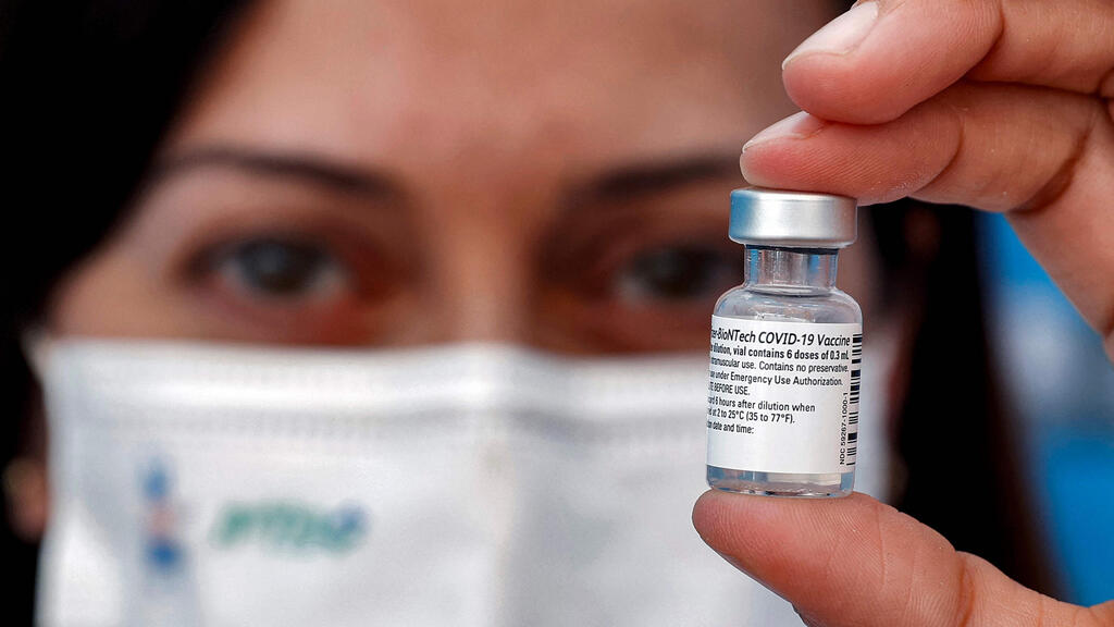 COVID-19 coronavirus vaccine (Photo: AFP) A medic holds up a vial of the Pfizer-BioNTech COVID-19 coronavirus vaccine at a vaccination centre at the Atid al-Najah High School for the Sciences at the city of Taibeh in northern Israel on August 19, 2021