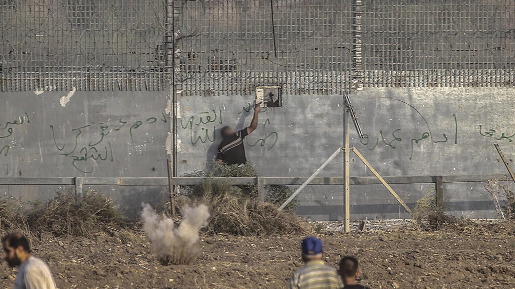 A Palestinian gunman shooting an Israeli sniper during a riot along the Gaza border fence (Photo: EPA) פלסטיני יורה לעבר חיילי צה"ל בגבול רצועת עזה
