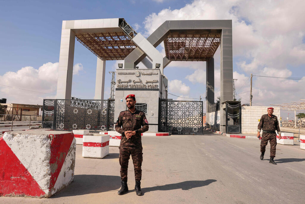 Members of Palestinan security forces stand guard at the closed down Rafah border crossing to Egypt in the southern Gaza Strip, on August 23, 2021