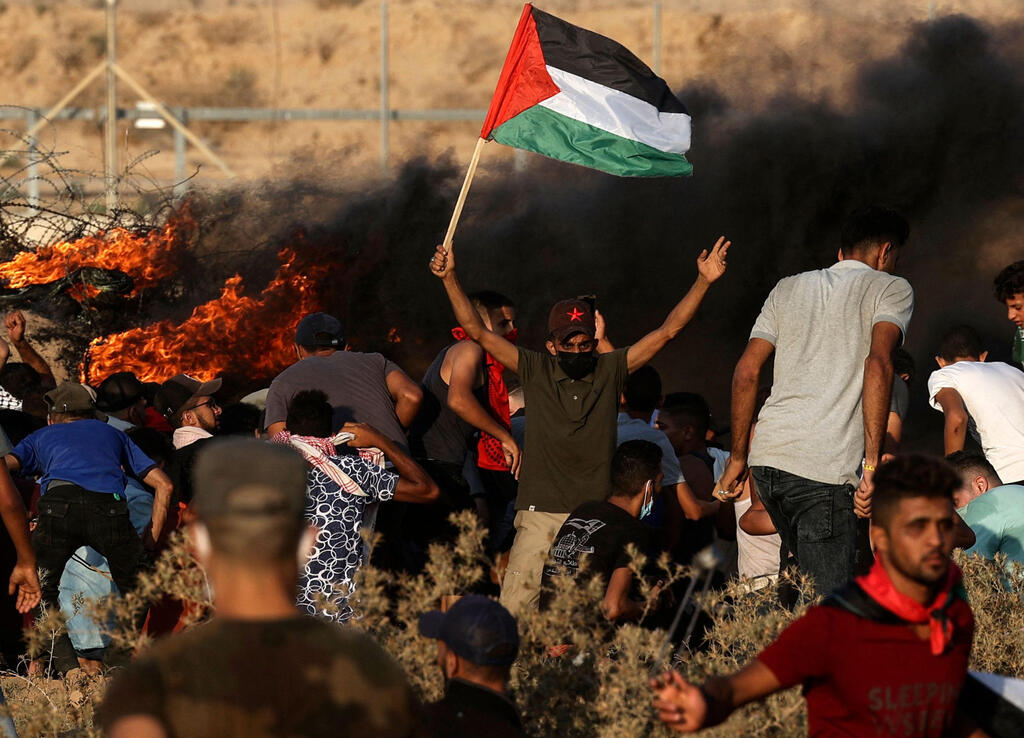 Palestinian protestors on the Gaza border fence (Photo: AFP) עימותים בגבול רצועת עזה