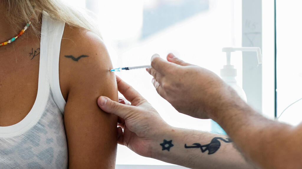 A woman receives the third dose of the coronavirus vaccine in Tel Aviv late last month (Photo: Reuters) מתחסנים בחיסון שלישי