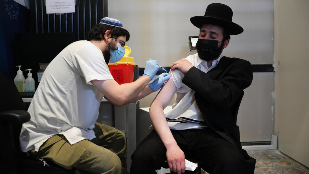 A Haredi man receiving the third jab in Tel Aviv (Photo: EPA) מתחסנים בחיסון שלישי