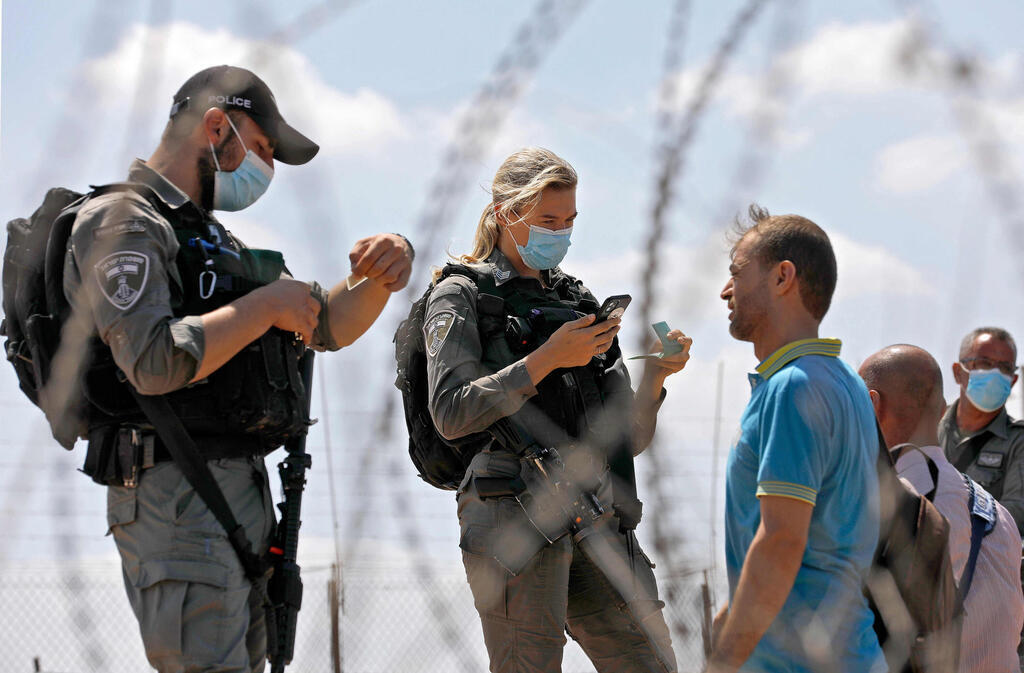 Police forces question Palestinian workers near the border crossing into the northern West Bank on Tuesday 