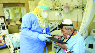 הרב מנדי ליפקין מ"לב חב"ד - אגף הפעלות בבתי רפואה של צעירי חב"ד", מסייע ליהודי להניח תפילין בתוך מחלקת הקורונה כשהוא ממוגן מכף רגל ועד ראש