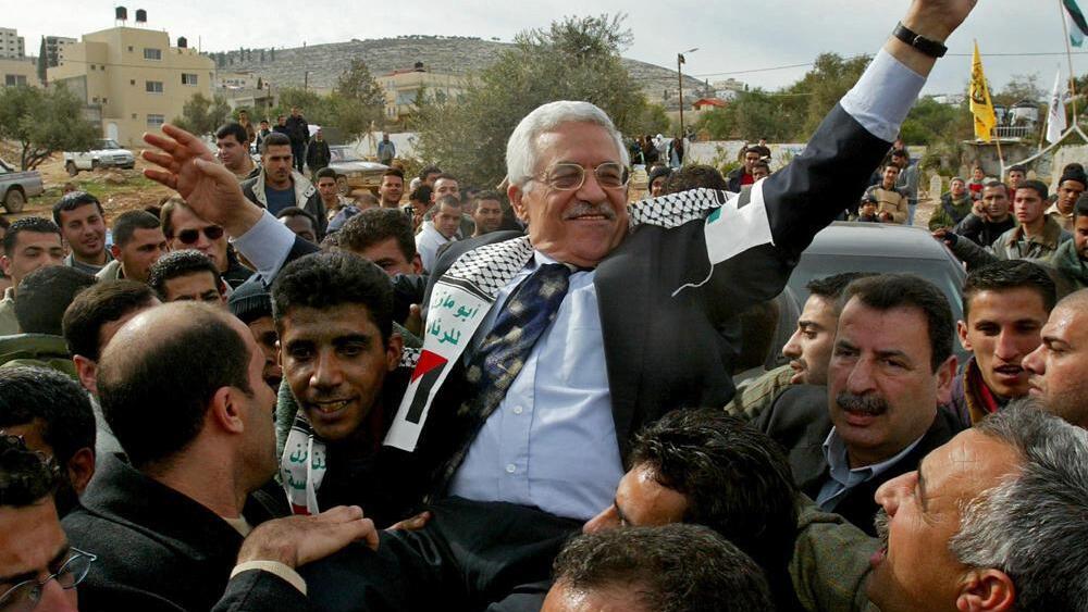 then Interim Palestinian leader Mahmoud Abbas, and front-runner in the upcoming presidential elections, is carried by the Al Aqsa Martyrs' Brigades leader in West Bank, Zakaria Zubeidi, center left, during a campaign visit to the Jenin refugee camp 