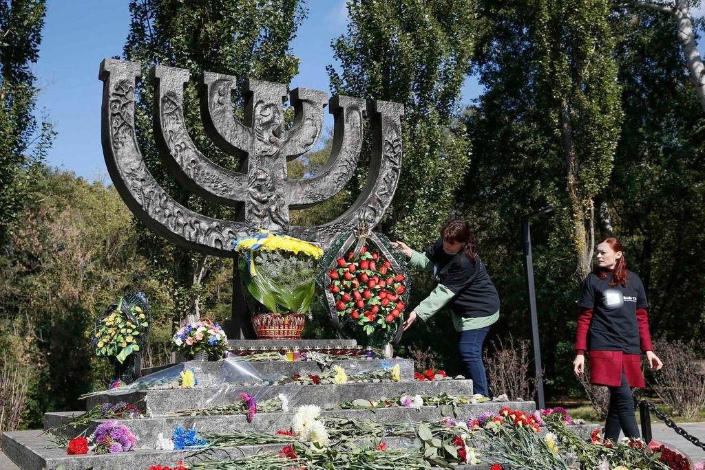 A woman places flowers at a monument commemorating the victims of Baby Yar (Babiy Yar), one of the biggest single massacres of Jews during the Nazi Holocaust 