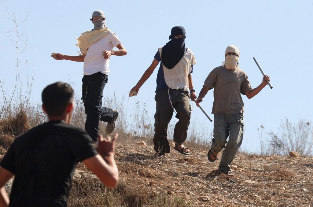 Masked Jewish settlers clash with Palestinians in the West Bank village of Assira al-Kibliya, Tuesday, Sept. 20, 2011 