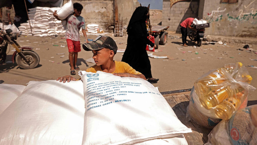 Palestinians collect food aid at a distribution centre run by United Nations Relief and Works Agency (UNRWA), in Gaza City 
