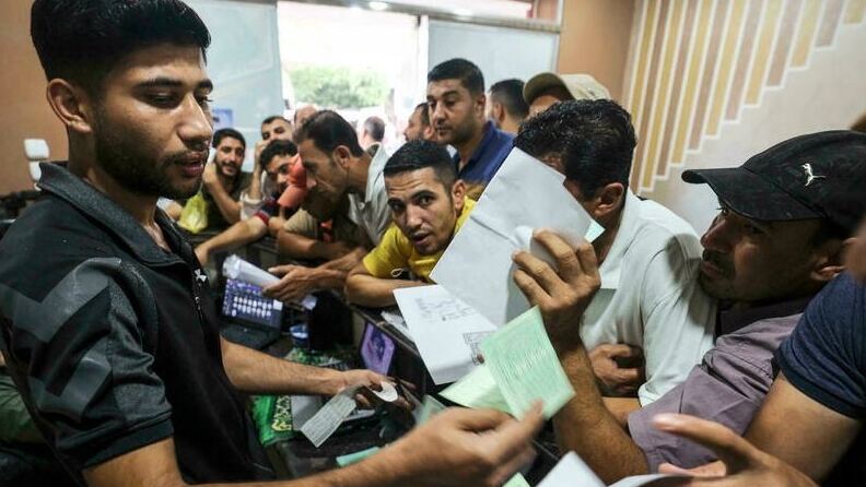 Palestinian men gather to apply for work permits in Israel, at Jabalia refugee camp in the northern Gaza Strip