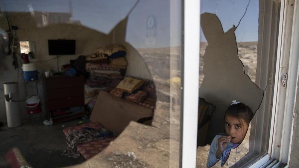 A Palestinian girl is seen through her family house's shattered window following a settlers' attack (Photo: AP) A Palestinian girl is seen through her family house's shattered window following a settlers' attack from nearby settlement outposts on the Bedouin community, in the West Bank village of al-Mufagara