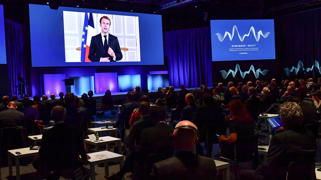 France's President Emmanuel Macron appears on a screen at the Malmo International Forum on Holocaust Remembrance and Combating Antisemitism, in Malmo, Sweden 