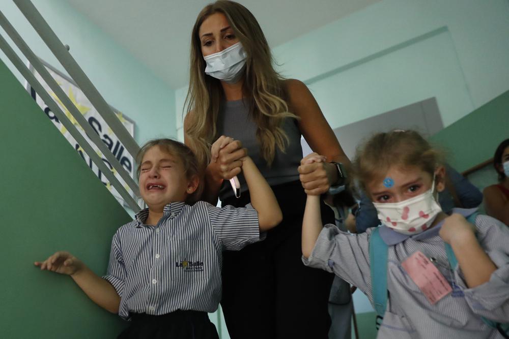 A Lebanese mother evacuates her kids who are afraid of sounds from armed clashes in the Christian neighborhood of Ain el-Remaneh, in Beirut, Lebanon (Photo: AP) A Lebanese mother evacuates her kids who are afraid of sounds from armed clashes in the Christian neighborhood of Ain el-Remaneh, in Beirut, Lebanon