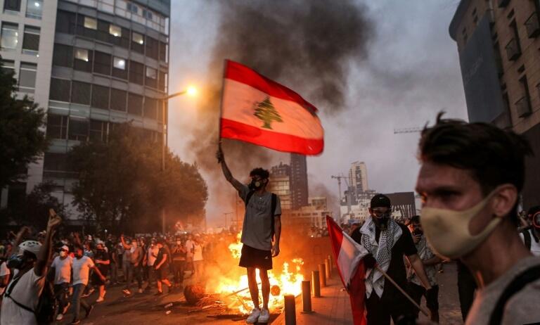 A protester holds a flag during clashes with armed forces in Lebanon, whose economy is in a tailspin (Photo: AFP) A protester holds a flag during clashes with armed forces in Lebanon, whose economy is in a tailspin