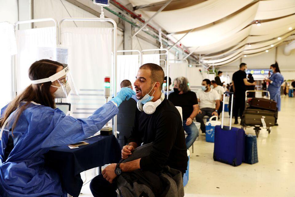 A healthcare worker takes a swab sample from a traveler for a coronavirus test at the Ben-Gurion International Airport (Photo: Reuters) A healthcare worker takes a swab sample from a traveller for a coronavirus disease (COVID-19) test at the Ben Gurion International Airport