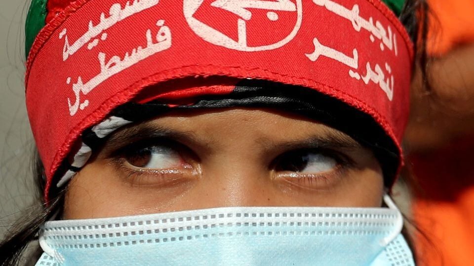 A girl wearing a protective face mask and the headband of the Popular Front for the Liberation of Palestine (PFLP) looks on during a rally in Gaza (Photo: Reuters) A girl wearing a protective face mask and the headband of the Popular Front for the Liberation of Palestine (PFLP) looks on during a rally to show solidarity with hunger-striking Palestinian prisoner Maher Al-Akhras, who is held by Israel, in Gaza