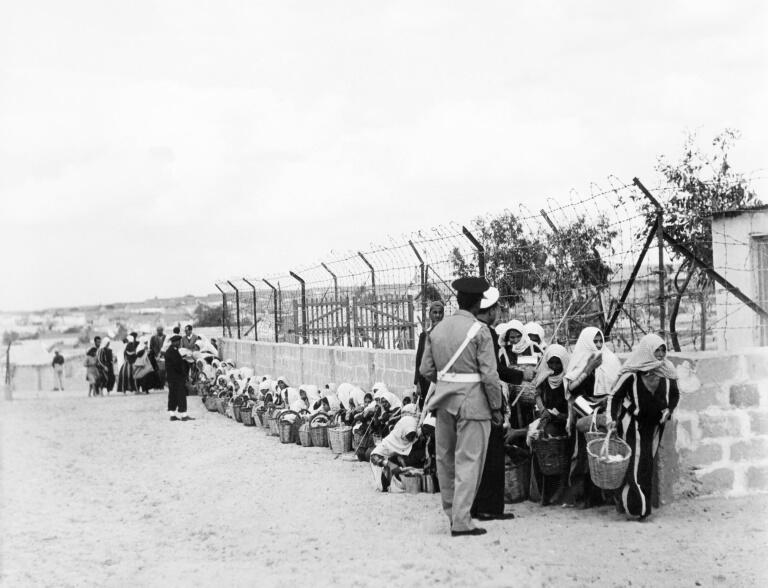 Palestinian refugees queue for food distributed by the UNRWA (United Nations Relief and Works Agency for Palestinian refugees) at a camp in Gaza on November 9, 1956