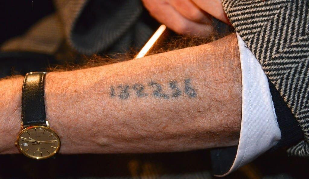 A Holocaust survivor shows a tattoo from Auschwitz concentration camp, at a memorial ceremony in Stockholm, Sweden, in 2013 
