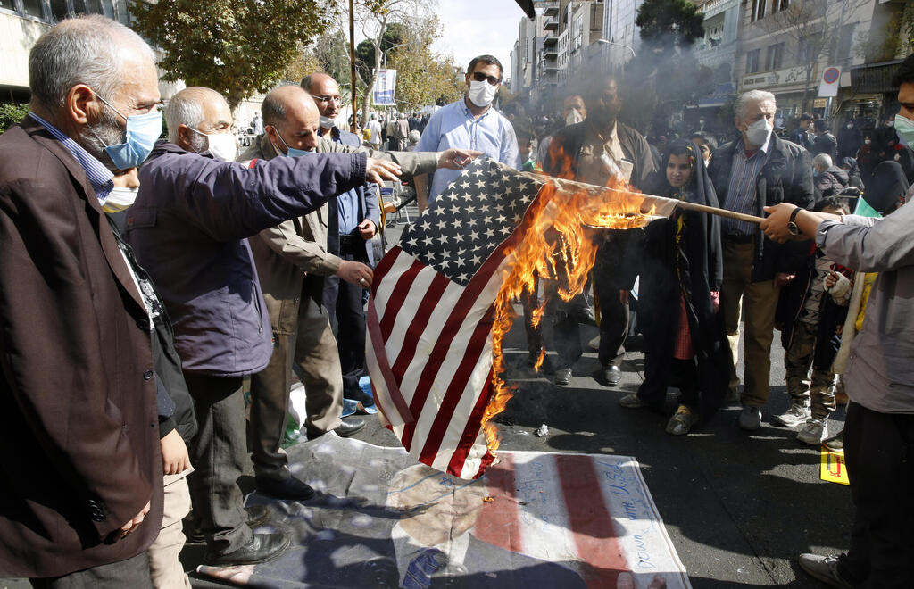 People burn a US flag during an anti-US demonstration marking the 42nd anniversary of US Embassy takeover, in front of the former US embassy in Tehran, Iran 