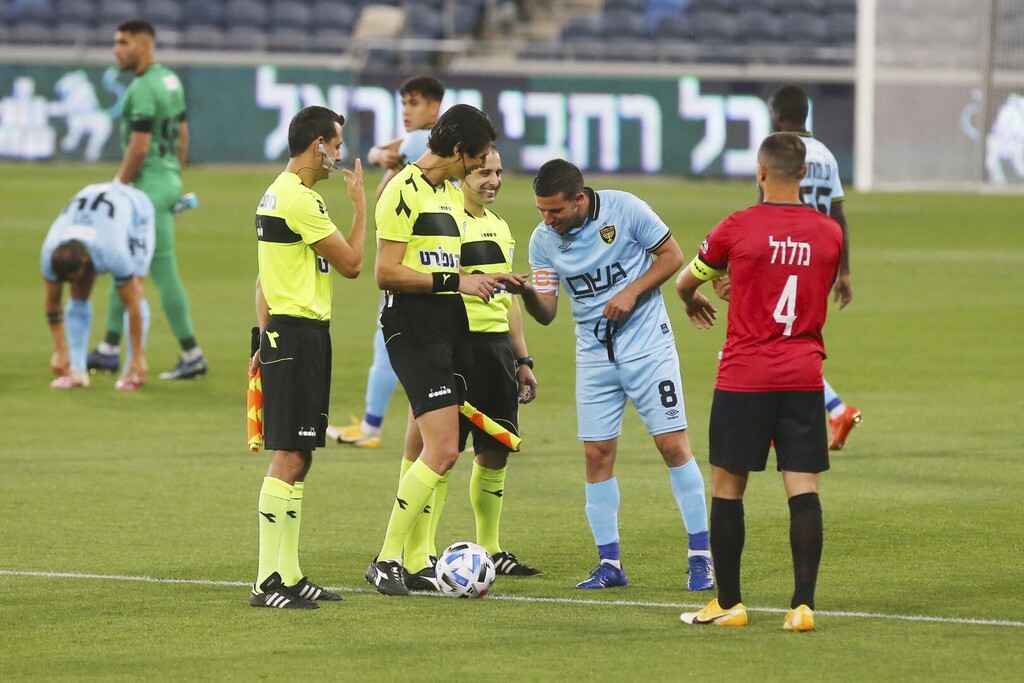 משחקה הביתי של הפועל חיפה נגד בית"ר ירושלים בליגת העל היה המשחק הראשון שבו שפטה ספיר ברמן, שופטת הכדורגל הטרנסג'נדרית הראשונה בישראל, לאחר שהודיעה על השינוי המגדרי שהיא עוברת. בתמונה, עידן ורד, קפטן בית"ר ירושלים, מתבונן מקרוב בציפורניה של ברמן, המשוחות בלק. אצטדיון סמי עופר, חיפה, 3 במאי 2021 (צילום: נמרוד גליקמן) משחקה הביתי של הפועל חיפה נגד בית"ר ירושלים בליגת העל היה המשחק הראשון שבו שפטה ספיר ברמן, שופטת הכדורגל הטרנסג'נדרית הראשונה בישראל, לאחר שהודיעה על השינוי המגדרי שהיא עוברת. בתמונה, עידן ורד, קפטן בית"ר ירושלים, מתבונן מקרוב בציפורניה של ברמן, המשוחות בלק. אצטדיון סמי עופר, חיפה, 3 במאי 2021