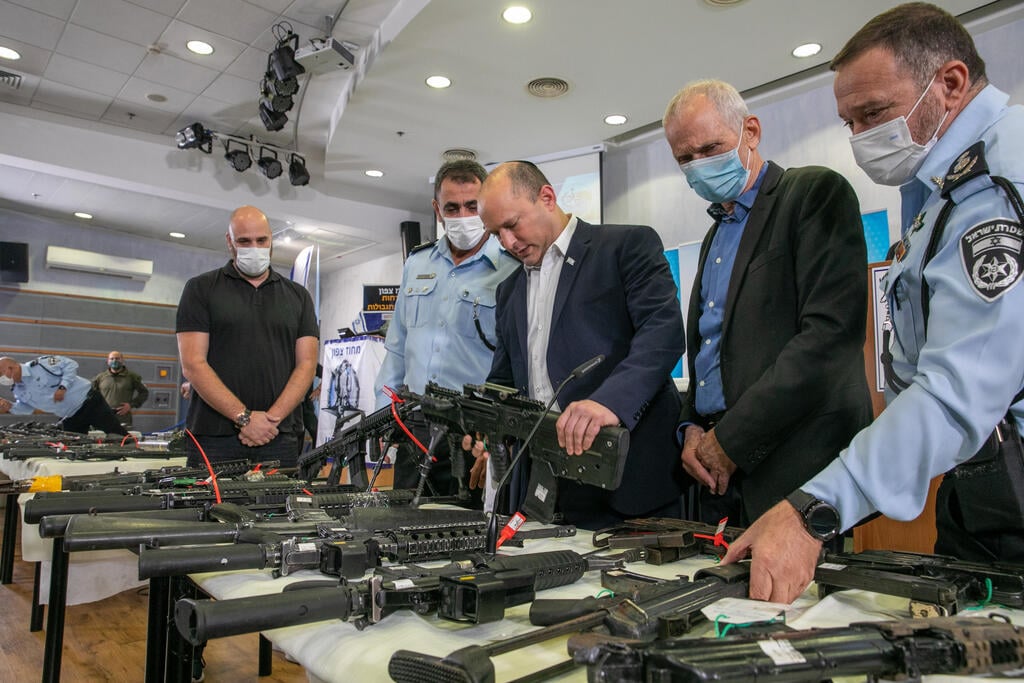 Police Chief Kobi Shabtai, left, showing Prime Minister Naftali Bennett and Interior Security Minister Omer Barlev illegal weapons seized by police (Photo: Flash 90) סקירה של הנשקים שנתפסו לאחר מבצע "אושן"