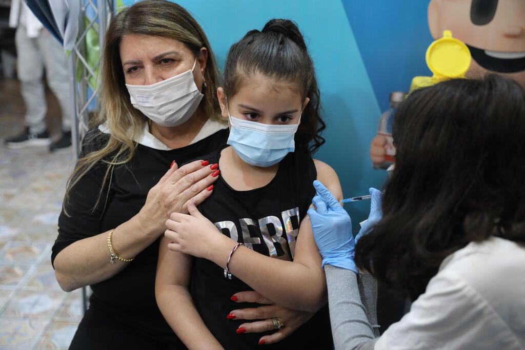A child receives her coronavirus vaccine at a Clalit HMO clinic in Jerusalem (Photo: EPA) חיסוני ילדים בירושלים