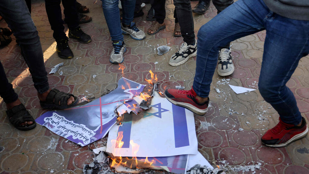 Palestinians burning Israeli flags, Gaza, November 2021 (Photo: AFP) פלסטינים שורפים דגלי ישראל וכרזות של פריטי פאטל ברפיח